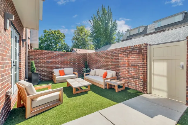 a backyard of a house with fountain table and chairs