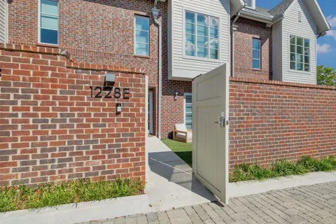 a view of a brick house with a small yard