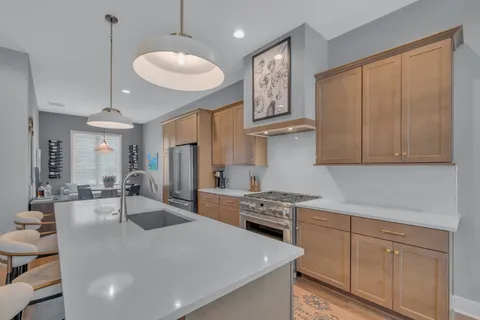 a kitchen with stainless steel appliances granite countertop a sink stove and refrigerator