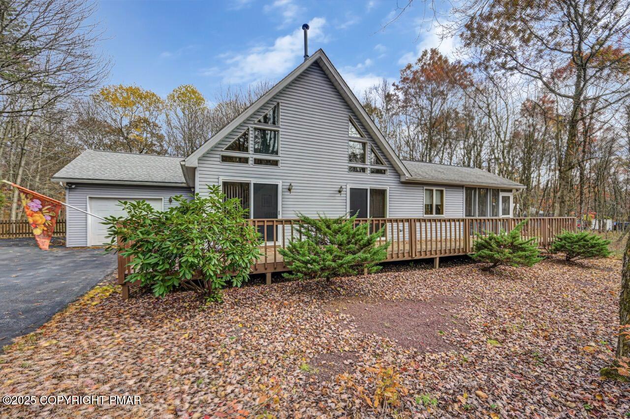 a view of a house with a small yard and large tree