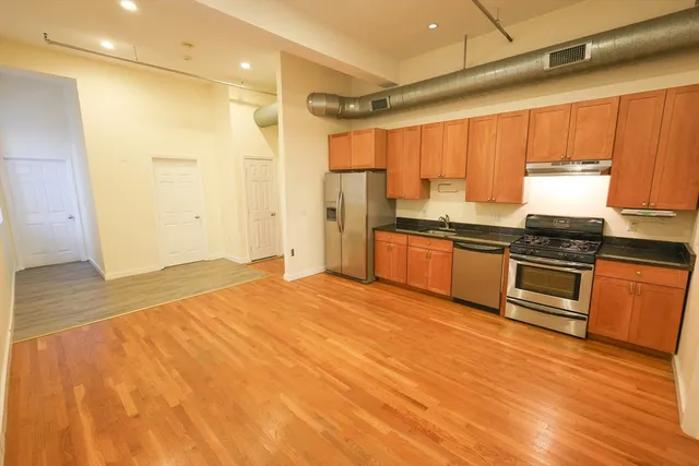 a kitchen with stainless steel appliances granite countertop a stove a sink and a refrigerator