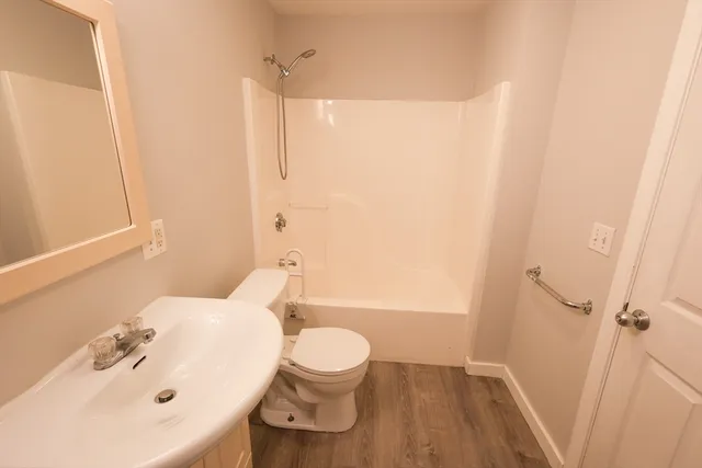 a bathroom with a sink a toilet and shower