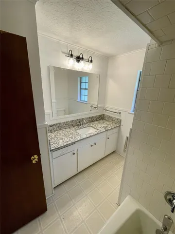 a bathroom with a granite countertop sink a toilet and mirror