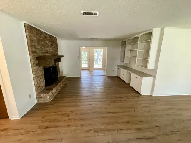 a view of a livingroom with wooden floor and a fireplace