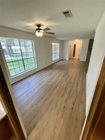 wooden floor in an empty room with a window
