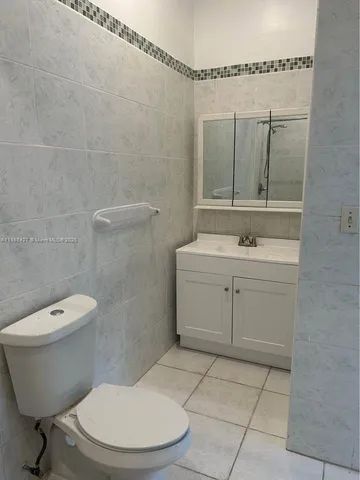 a bathroom with a toilet a sink and mirror