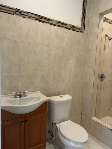a white toilet sitting next to a bath tub and a shower