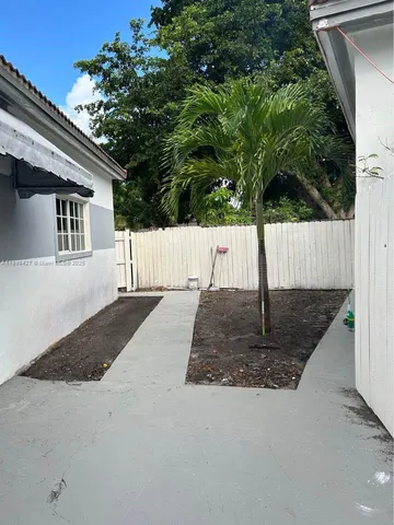 a view of backyard with small cabin and wooden fencing