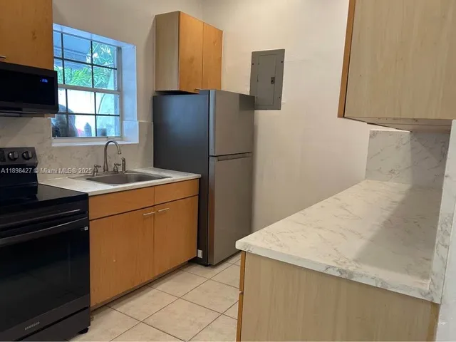 a kitchen with a sink a refrigerator and window