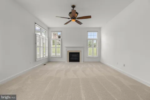 a view of an empty room and chandelier fan