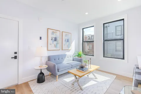 a living room with furniture a rug and a window