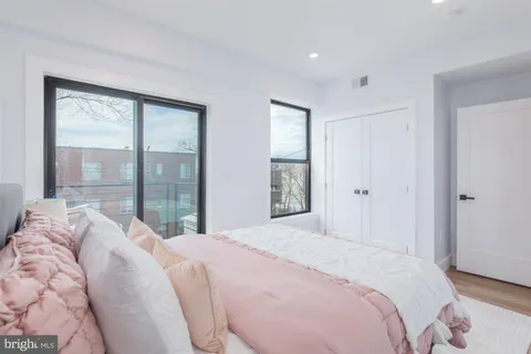 a bedroom with a large bed and a large window