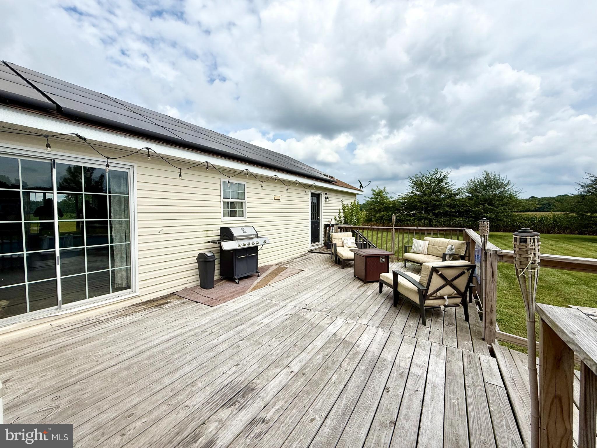 35777 Cobbs Hill Road Willards, MD 21874 - Photo 37 of 46 a view of a roof deck with table and chairs a barbeque with wooden floor and fence