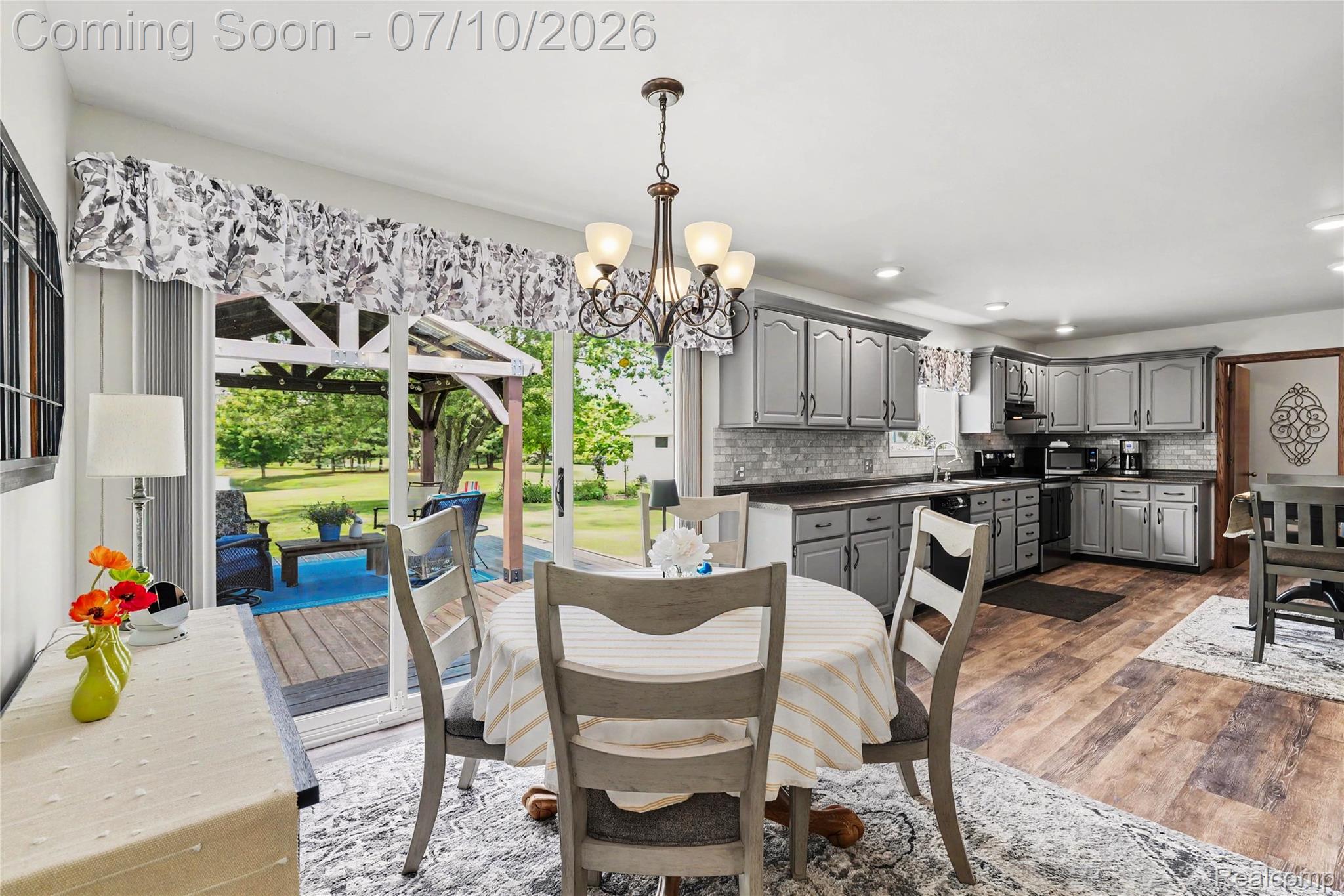 2180 Hurst Road St. Clair, MI 48079 - Photo 14 of 39 Dining area featuring a chandelier, wood-finish flooring, and direct access to an outdoor deck with a gazebo