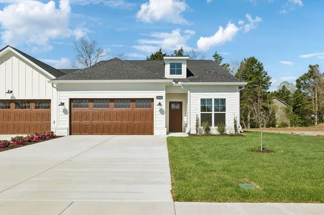 a front view of a house with a yard and trees