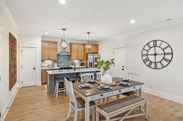 a kitchen with stainless steel appliances a table chairs in it and white cabinets