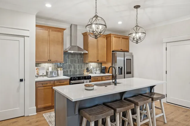 a kitchen with stainless steel appliances granite countertop a sink a stove top oven a counter space and cabinets