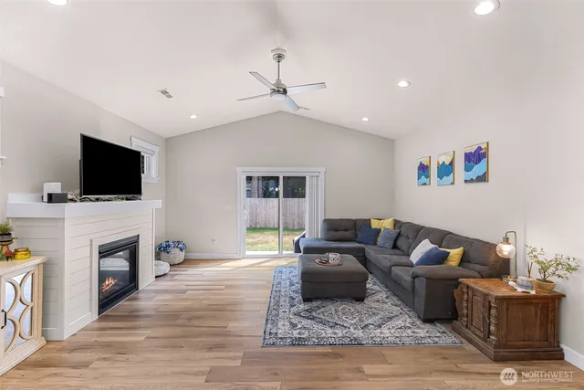 a living room with furniture a flat screen tv and a fireplace
