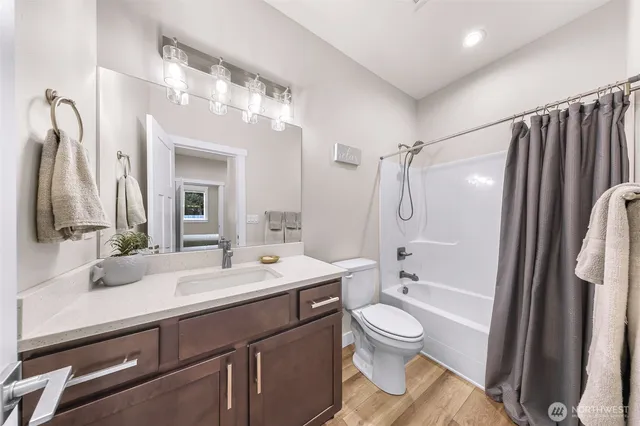 a bathroom with a double vanity sink toilet mirror and shower