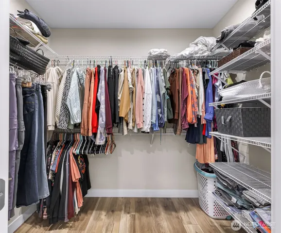 a view of walk in closet with clothes