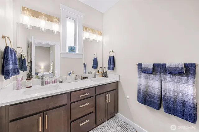 a bathroom with a double vanity sink a mirror and shower
