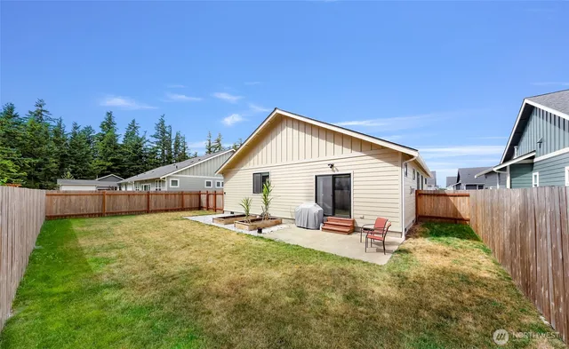 a backyard of a house with table and chairs
