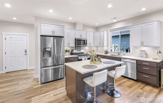 a kitchen with refrigerator cabinets and wooden floor