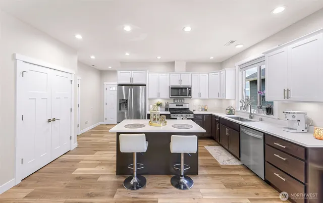 a kitchen with a dining table chairs refrigerator and cabinets