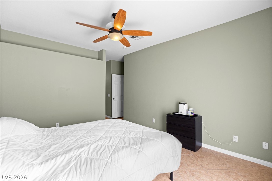 3238 Mystic Ridge Court Las Vegas, NV 89129 - Photo 9 of 31 A comforting bedroom retreat features a ceiling fan, offering a tranquil space to unwind.