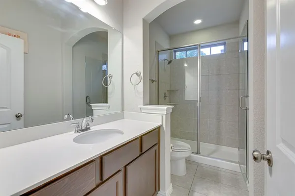 a bathroom with a sink a toilet a shower and a mirror
