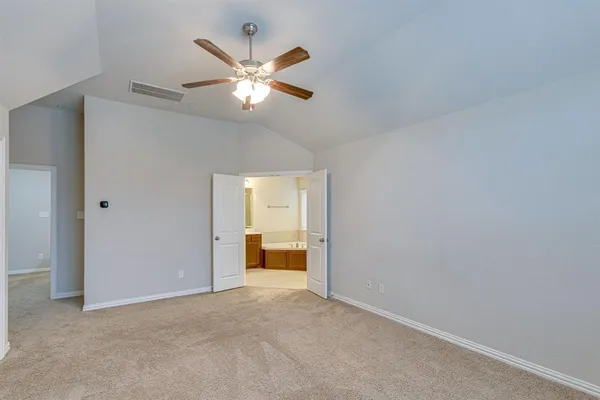 a view of an empty room with a chandelier fan
