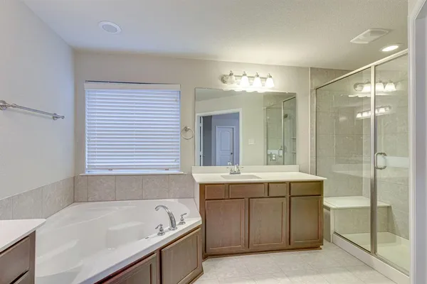 a bathroom with a tub sink and mirror