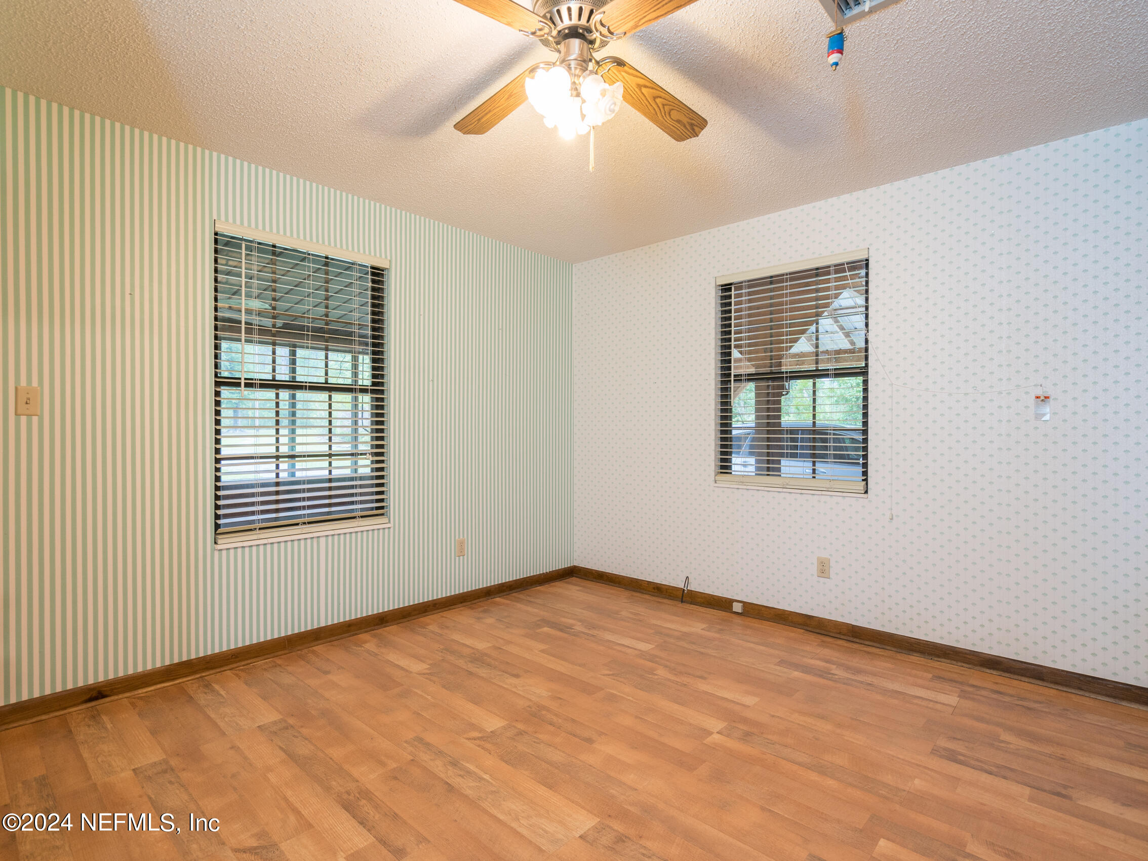 27278 Inspiration Way Hilliard, FL 32046 - Photo 19 of 25 an empty room with a chandelier fan and windows
