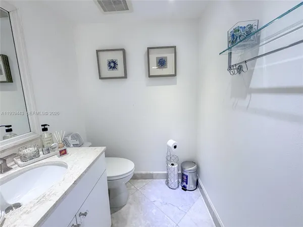 a bathroom with a sink mirror and toilet