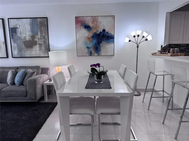 a view of a dining room with furniture a couch and wooden floor