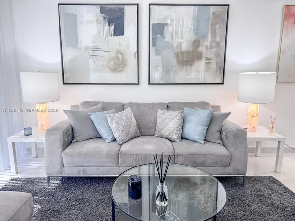 a living room with furniture and a painting on the wall