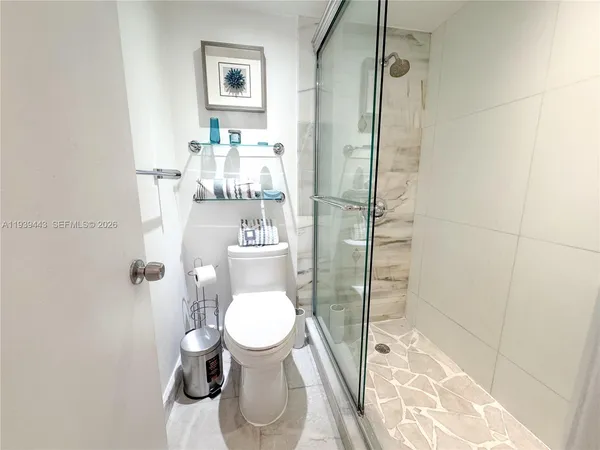 a bathroom with a toilet and a shower