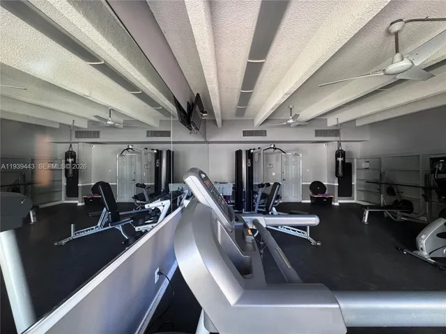 a room with gym equipment and wooden floor