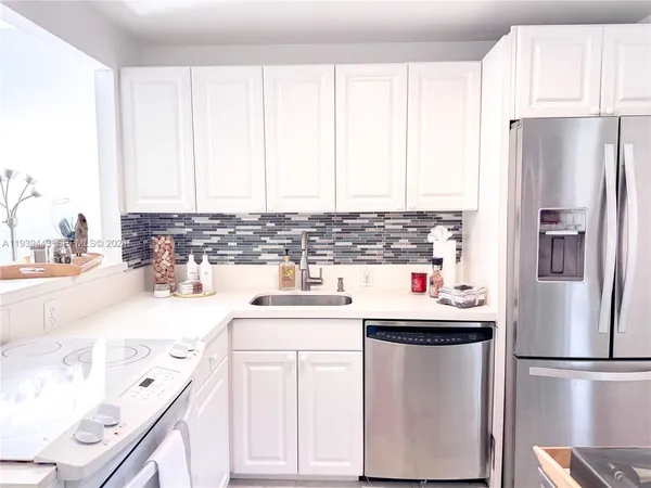 a kitchen with a sink a refrigerator and window