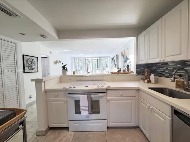 a kitchen with a sink stove and cabinets