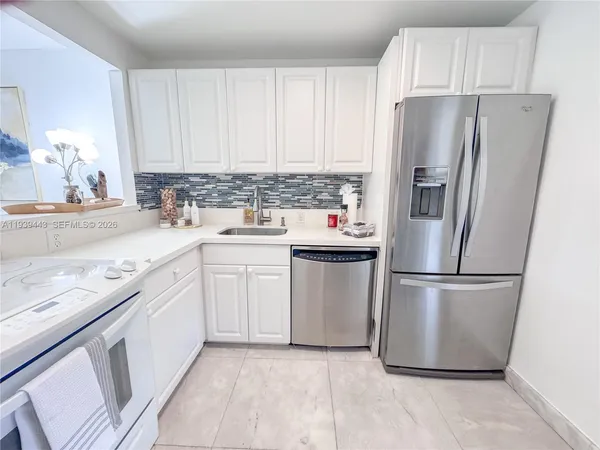 a kitchen with a refrigerator sink and cabinets