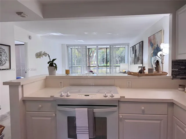 a kitchen with a sink a stove and white cabinets