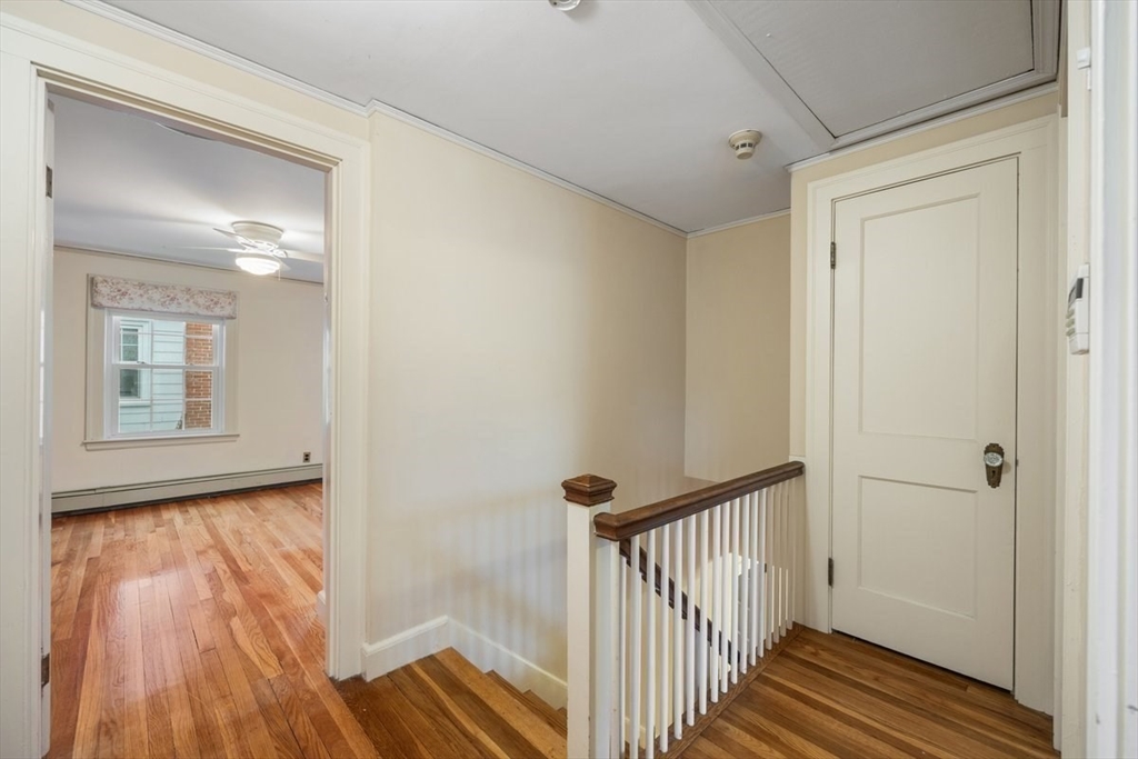 18 Bates Road Arlington, MA 02474 - Photo 16 of 42 a view of a hallway with wooden floor and a bathroom