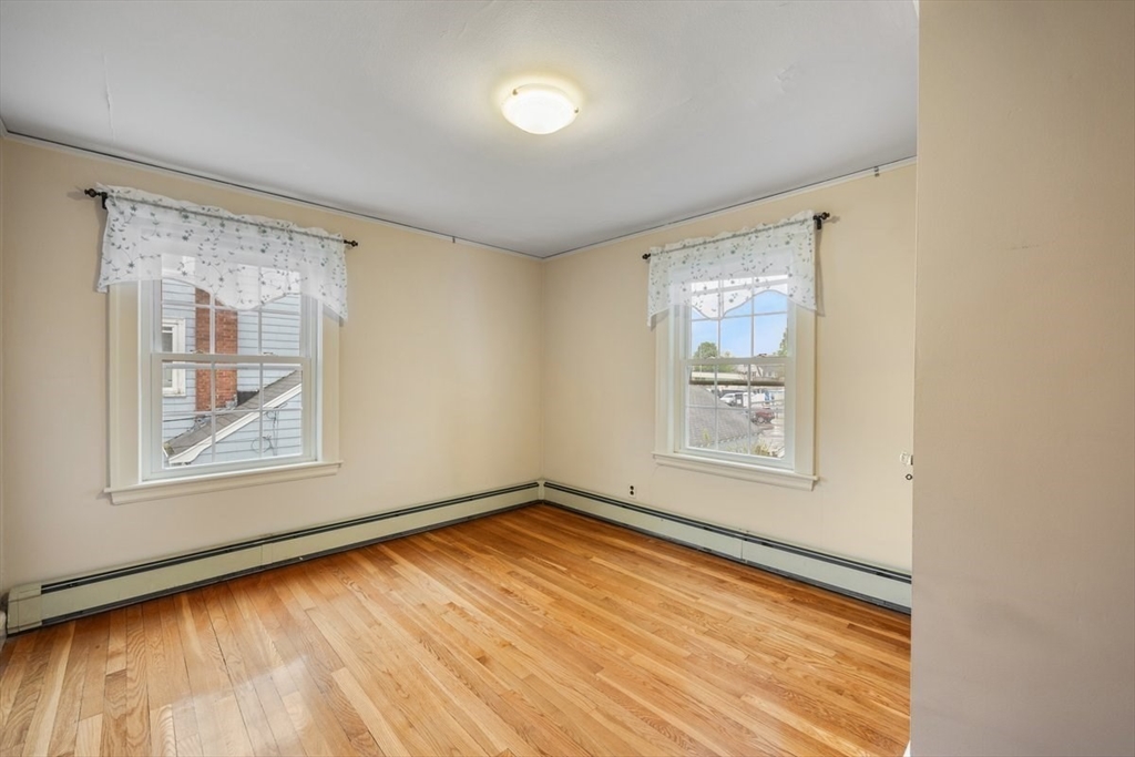 18 Bates Road Arlington, MA 02474 - Photo 24 of 42 a view of an empty room with wooden floor and a window
