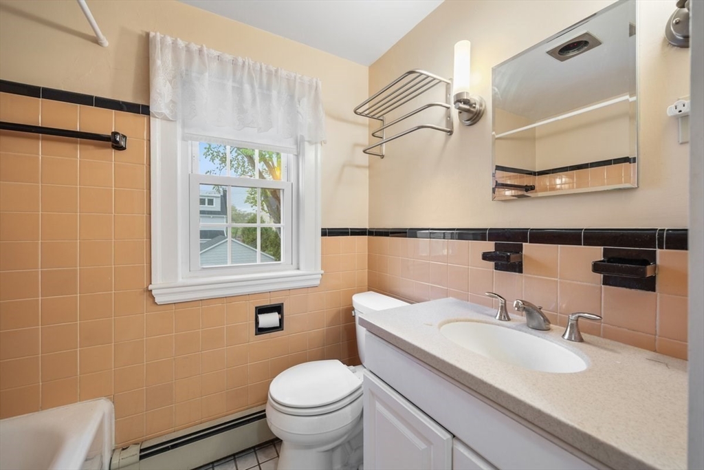 18 Bates Road Arlington, MA 02474 - Photo 26 of 42 a bathroom with a granite countertop sink toilet and a mirror