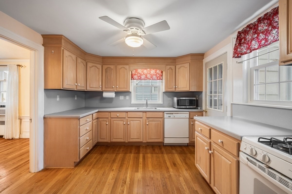 18 Bates Road Arlington, MA 02474 - Photo 5 of 42 a kitchen with granite countertop white cabinets a sink a stove a oven and wooden floors