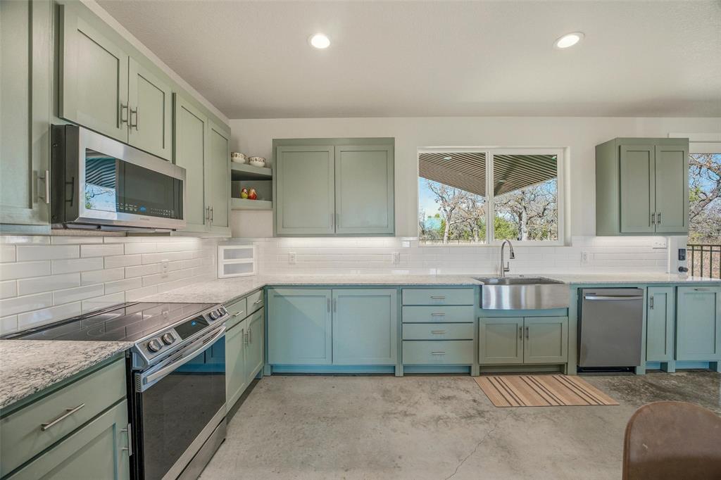 1525 North Bosley Road Santo, TX 76472 - Photo 14 of 40 a kitchen with sink cabinets and microwave