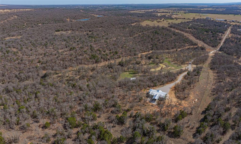 1525 North Bosley Road Santo, TX 76472 - Photo 2 of 40 an aerial view of house with yard and mountain in the background
