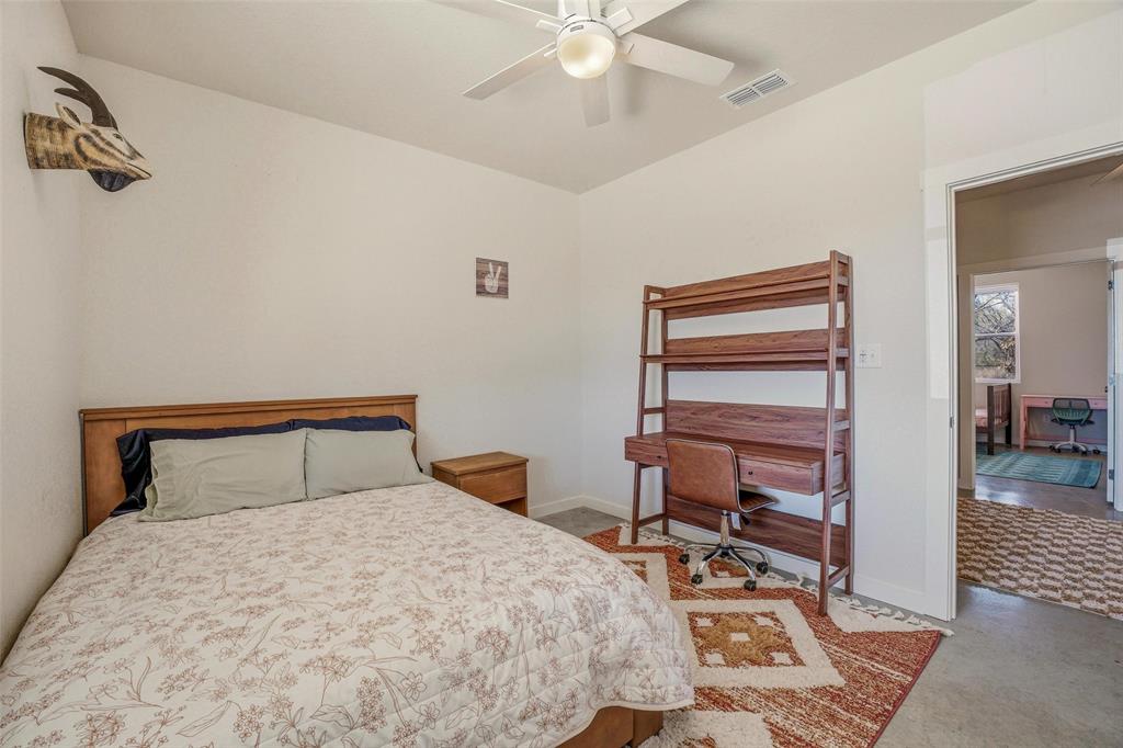 1525 North Bosley Road Santo, TX 76472 - Photo 24 of 40 a bedroom with a bed and a chandelier