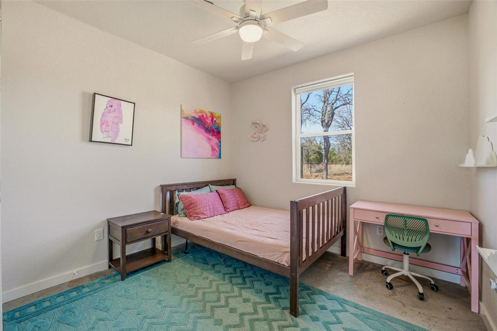 1525 North Bosley Road Santo, TX 76472 - Photo 25 of 40 a living room with a baby crib furniture a chandelier and a window